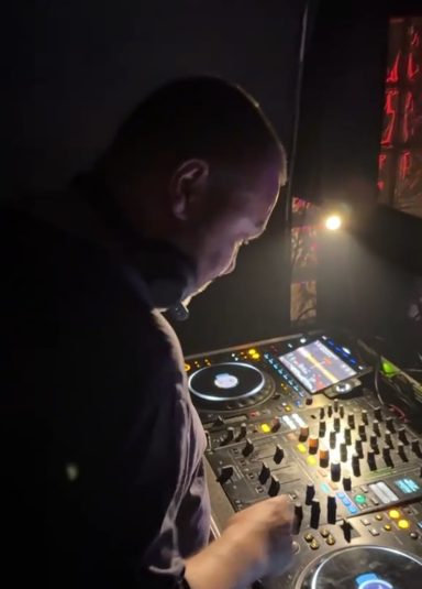 DJ Fletcha DJing live behind the decks